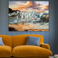 Lerretsbilde 70x100 cm - Fem hvite hester galopperer gjennom bølgene ved solnedgang