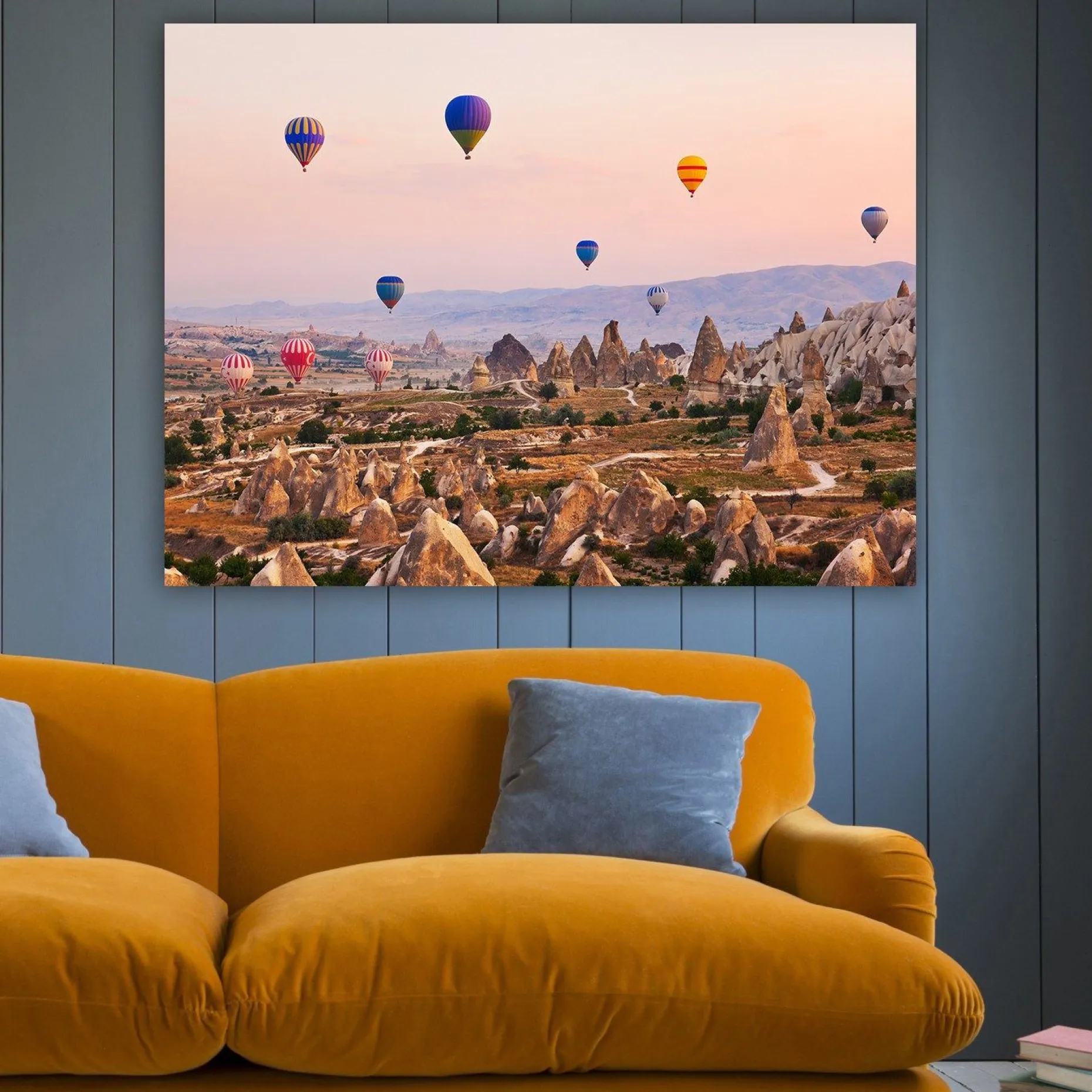 Lerretsbilde 70x100 cm - Flere fargerike varmluftsballonger svever over et dramatisk landskap med unike fjellformasjoner