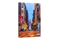 Lerretsbilde 70x100 cm - Livlig bybilde med Galatatårnet som hovedfokus i en smal gate