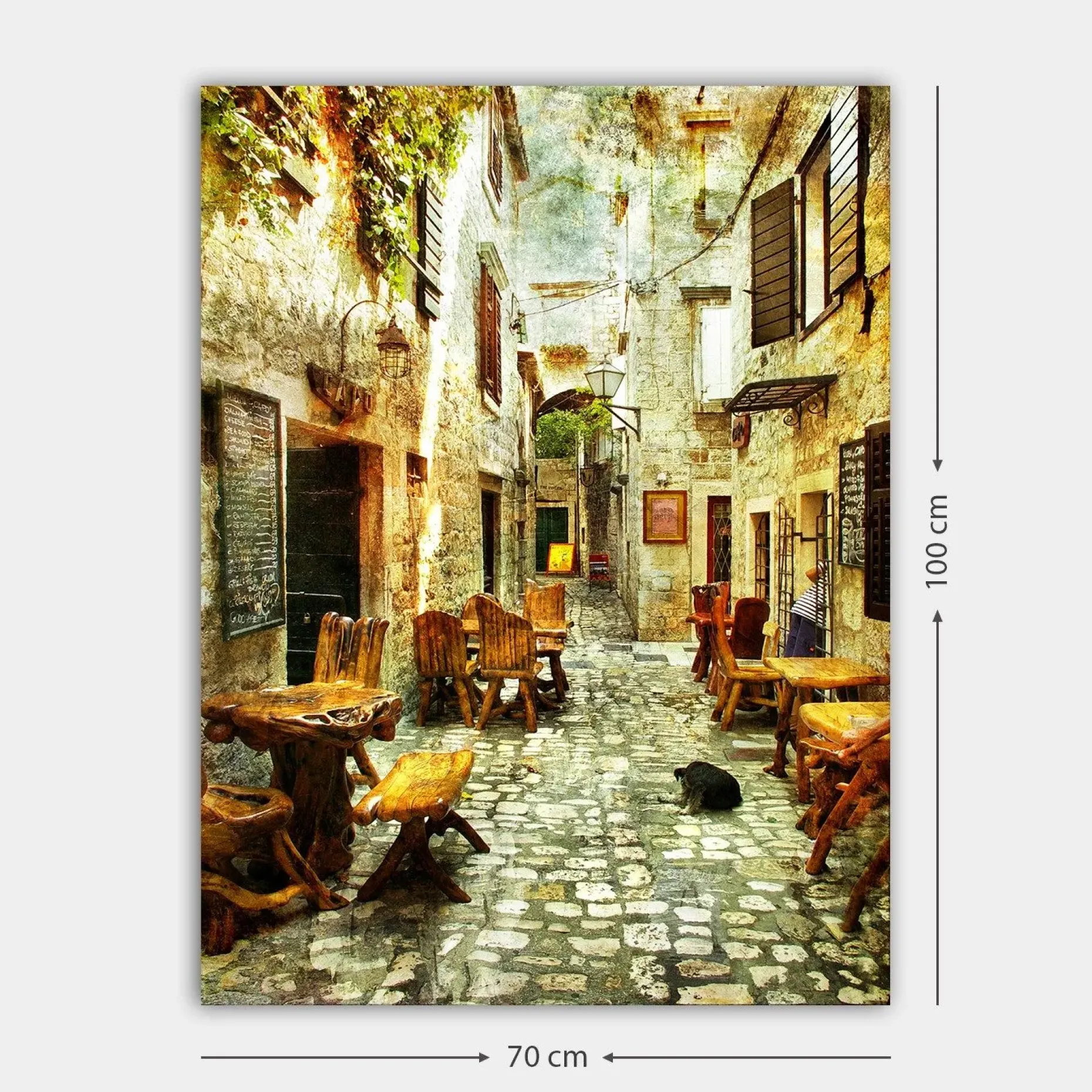 Lerretsbilde 70x100 cm - Pittoresk smug med trebord og stoler, omgitt av gamle steinhus