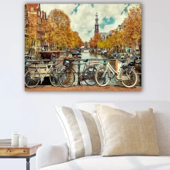 Lerretsbilde 70x100 cm - Sykler ved en kanal i Amsterdam omgitt av høstfarger