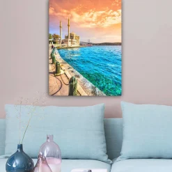 Lerretsbilde 70x100 cm - Vakker utsikt over en moské ved vannet med en bro i bakgrunnen under en fargerik himmel